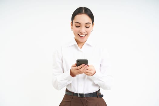 Young corporate woman, asian businesswoman with smartphone standing isolated on white background.