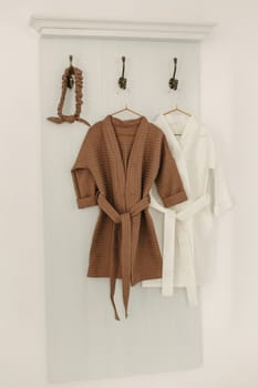 Linen bathrobes hang on a hanger in the bathroom.