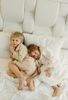 The brothers lie on the bed in bathrobes after a shower.