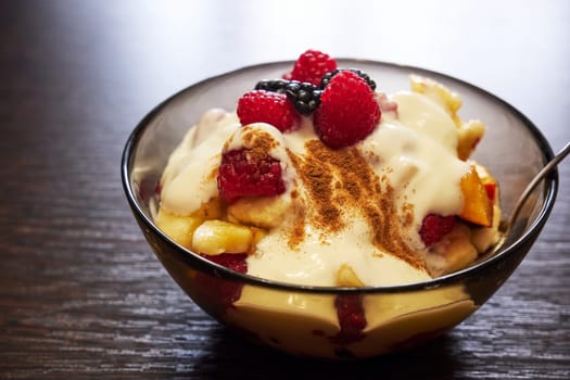 Fresh delicious fruit salad with yogurt on a wooden table