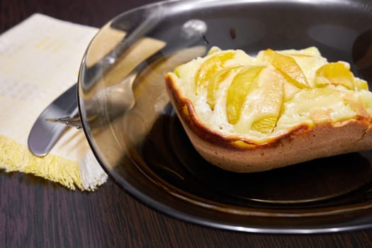 Piece of fruit pie on a plate close up. Transparent plate with a piece of fruit pie on the table