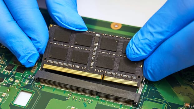 Installing a RAM module on a laptop motherboard close-up