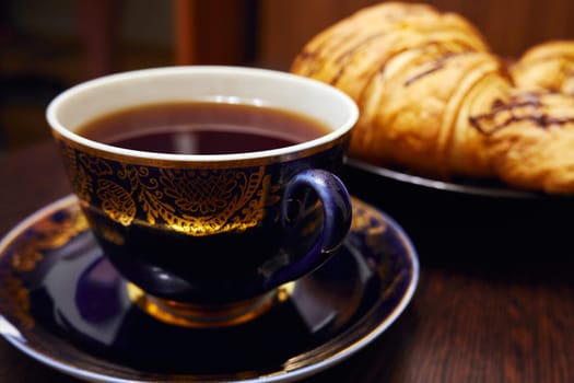 Black tea in a vintage porcelain cup on the table close-up