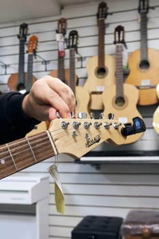 Ryazan, Russia - October 9, 2022: Guitar tuning before selling in a music store