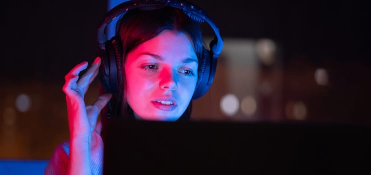 A young girl holds headphones and is listening and composing music, a woman sits with a laptop by the window in her room, works and enjoys the sound.