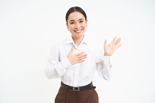 Friendly smiling businesswoman, introduces herself, says her name, stands over white background.