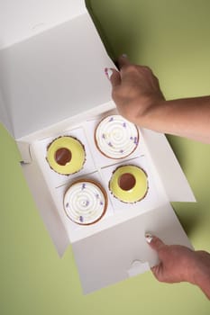 female hands open a box with different cakes dessert home delivery, High quality photo