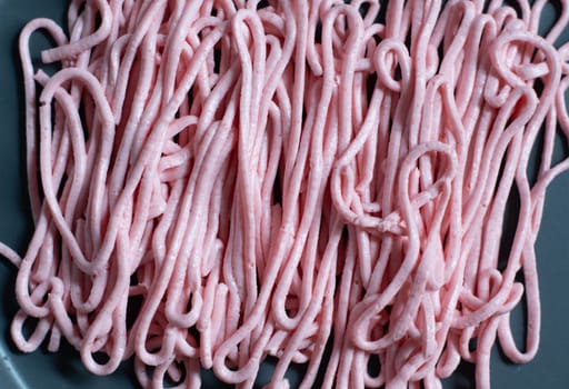 pink tarama pasta on a gray plate squeezed out of a cooking bag, creative texture. High quality photo