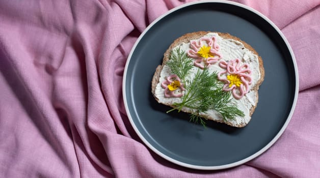 creative sandwich with soft cheese and pink pasta tarama greens, flowers are drawn on the sandwich. High quality photo