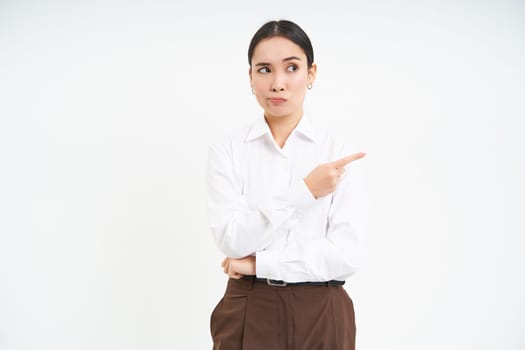 Image of female employee, office worker points finger at banner, shows promo advertisement on isolated white background.
