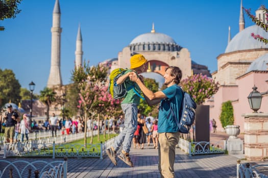 Father and son Tourists enjoy beautiful view on Hagia Sophia Cathedral, famous islamic Landmark mosque, Travel to Istanbul, Turkey. Traveling with kids concept. Sunny day architecture and Hagia Sophia Museum, in Eminonu, istanbul, Turkey. Turkiye.