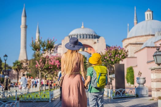 Mother and son Tourists enjoy beautiful view on Hagia Sophia Cathedral, famous islamic Landmark mosque, Travel to Istanbul, Turkey. Traveling with kids concept. Sunny day architecture and Hagia Sophia Museum, in Eminonu, istanbul, Turkey. Turkiye.
