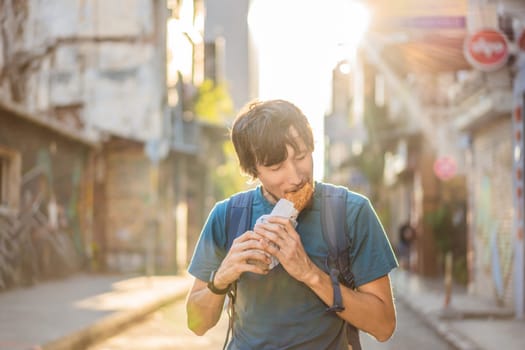 Man eating street food in Istanbul. Balik ekmek - fish in a bread, traditional Turkish fast food. Istanbul, Turkey.