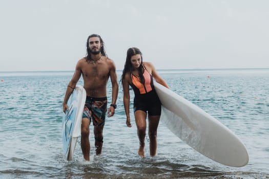 Sea woman and man on sup. Silhouette of happy young woman and man, surfing on SUP board, confident paddling through water surface. Idyllic sunset. Active lifestyle at sea or river