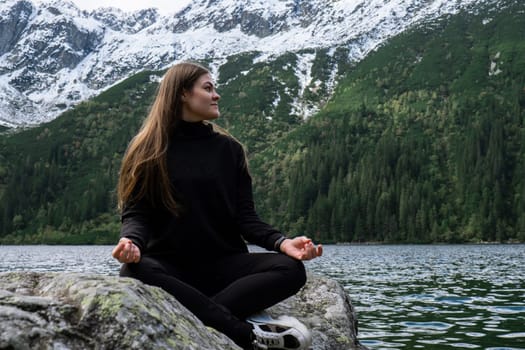 Young woman enjoying nature in Morskie Oko Snowy Mountain Hut in Polish Tatry mountains Zakopane Poland. Naturecore aesthetic beautiful green hills. Mental and physical wellbeing Travel outdoors tourist destination