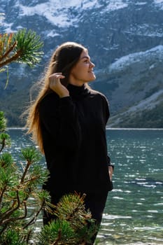 Young woman enjoying nature in Morskie Oko Snowy Mountain Hut in Polish Tatry mountains Zakopane Poland. Naturecore aesthetic beautiful green hills. Mental and physical wellbeing Travel outdoors tourist destination