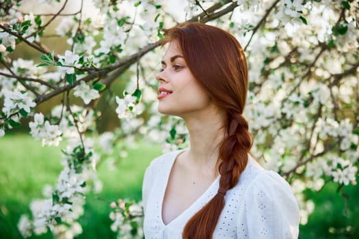 woman with flowers. gorgeous model in the spring garden. the girl near the tree in the spring. the concept of spring. young orchard. High quality photo