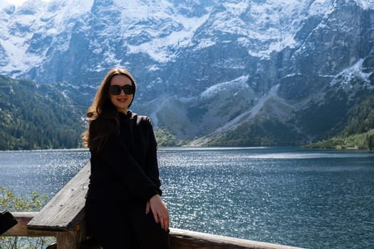 Young woman enjoying nature in Morskie Oko Snowy Mountain Hut in Polish Tatry mountains Zakopane Poland. Naturecore aesthetic beautiful green hills. Mental and physical wellbeing Travel outdoors tourist destination