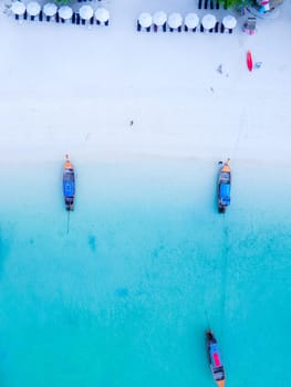 Longtail boats in the blue ocean of Koh Lipe Island Southern Thailand and a turqouse colored ocean