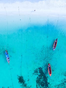 Longtail boats in the blue ocean of Koh Lipe Island Southern Thailand and a turqouse colored ocean