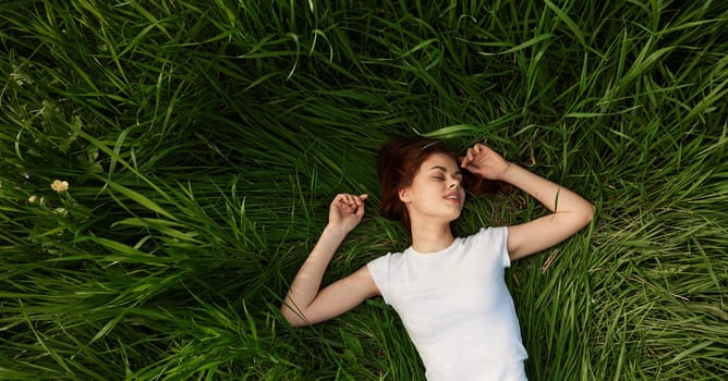 happy woman lies in green grass field. High quality photo