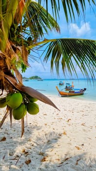 Longtail boats in the blue ocean of Koh Lipe Island Southern Thailand with turqouse colored ocean and white sandy beach