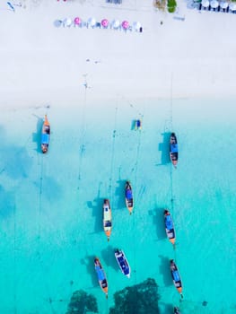 Longtail boats in the blue ocean of Koh Lipe Island Southern Thailand and a turqouse colored ocean