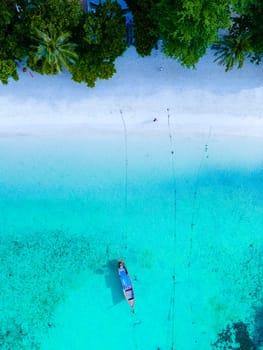 Longtail boats in the blue ocean of Koh Lipe Island Southern Thailand and a turqouse colored ocean