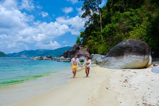 couple on beach in swimwear at Koh Adang Island near Koh Lipe Island Southern Thailand with turqouse colored ocean and white sandy beach Tarutao National Park