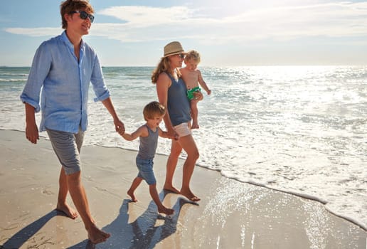 Walking on sunshine. a young family enjoying a summer day out at the beach