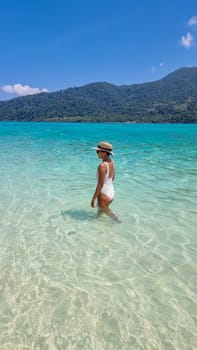 Koh Lipe Island Southern Thailand with turqouse colored ocean and white sandy beach at Ko Lipe. a women on vacation in Thailand walking at the beach