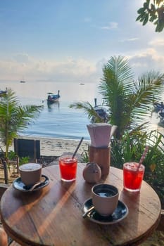 breakfast with coffee at the beach of Koh Lipe Island Southern Thailand with turqouse colored ocean and white sandy beach at Ko Lipe.