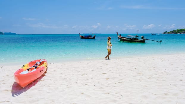 Koh Lipe Island Southern Thailand with turqouse colored ocean and white sandy beach at Ko Lipe. a Asian women on vacation in Thailand walking at the beach