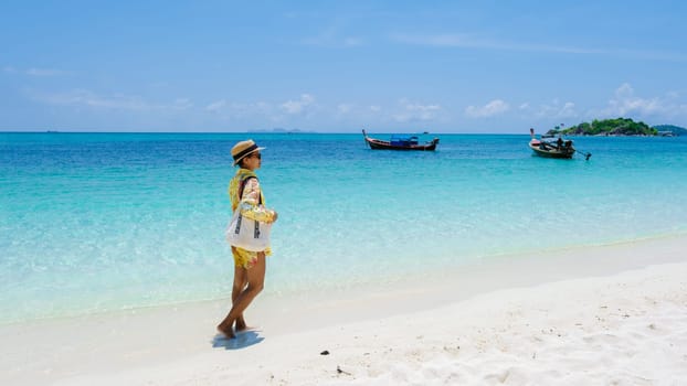 Koh Lipe Island Southern Thailand with turqouse colored ocean and white sandy beach at Ko Lipe. a Asian women on vacation in Thailand walking at the beach