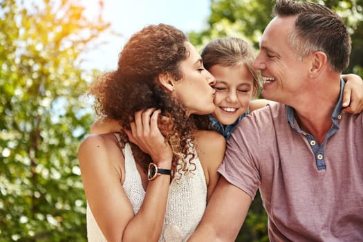 Kisses for our little princess. a family of three enjoying a day outdoors