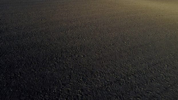 Landscape of plowed up land on agricultural field on sunny autumn day. Flying over plowed earth with black soil. Black soil. Agrarian background. Ground earth dirt priming. Aerial drone view.