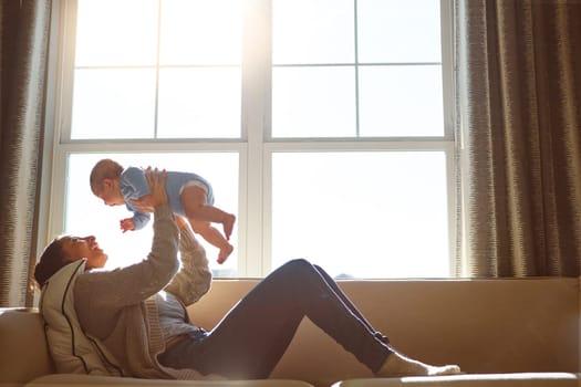 What a joy to be able to hold you. a young woman bonding with her baby boy on the sofa at home