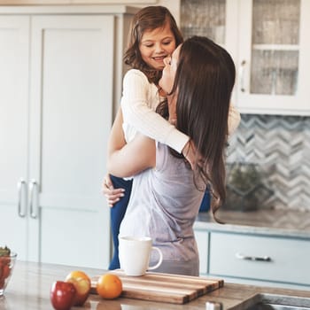 These arms were made for hugging. a happy mother hugging her cute little girl in the kitchen at home