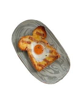 Homemade fried egg in a hole Bacon and Cheese toast on ceramic tray isolated on white background with clipping path. Sandwiches for breakfast, The concept of delicious food, Selective Focus.
