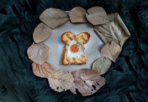 Homemade fried egg in a hole Bacon and Cheese toast on ceramic tray with dark background. Sandwiches for breakfast, The concept of delicious food, Top view, Space for text, Selective Focus.