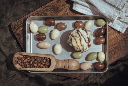Chocobon (Soft chocolate bun) topped with rich cream cheese frosting and Cinnamon served with assorted almond nuts chocolate in stainless tray with dark background. Top view, Space for text, Selective focus.