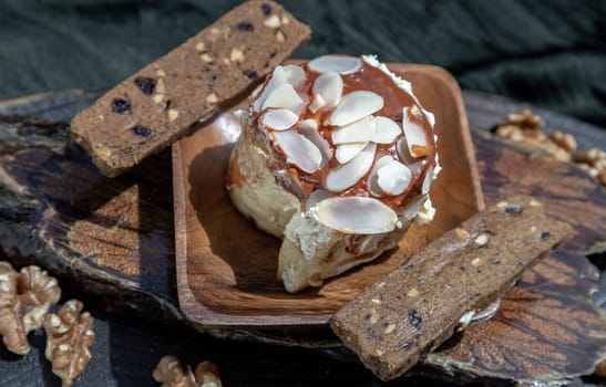 Close up of Thai milk tea Almond Minibon served with Stick cookies and Walnuts on wooden with dark background. Selective focus.