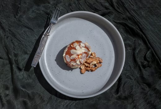 Thai milk tea Almond Minibon and Walnuts served with Metal fork on ceramic plate with dark background. Top view, Space for text, Selective focus.