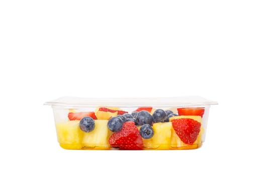 Fruit salad with pineapple, strawberries and blueberries in a plastic container on a white background. High quality photo