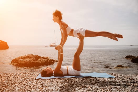 Woman sea yoga. Back view of free calm happy satisfied woman with long hair standing on top rock with yoga position against of sky by the sea. Healthy lifestyle outdoors in nature, fitness concept.