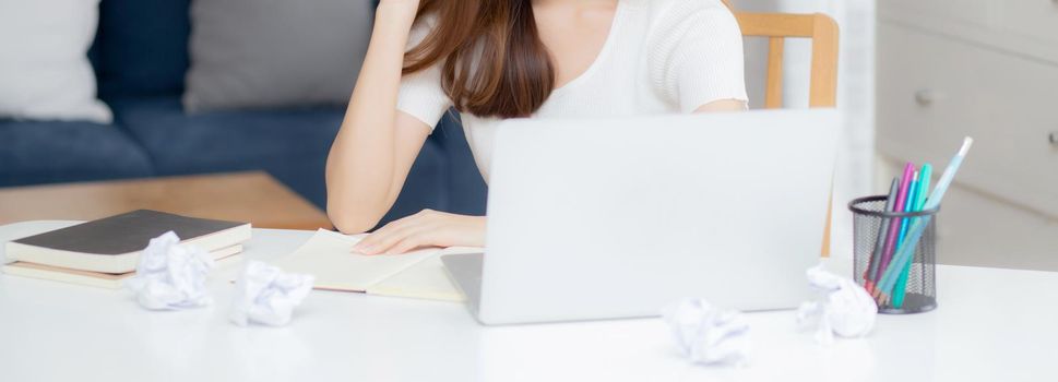 Young asian woman confident working at home with laptop computer and thinking idea for planning, freelance happy girl excited and success using notebook thoughtful and writing, business concept.