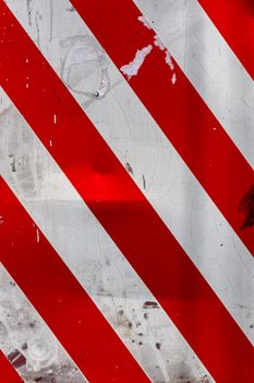 faded red and white diagonal stipes on flat steel sheet - caution road sign