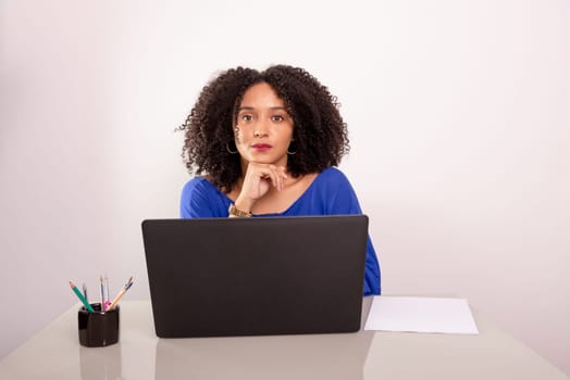 Young business woman working on her laptop and looking at the camera. financial manager