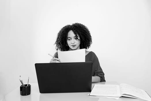 Black and white portrait of young businesswoman working with laptop. Home office.