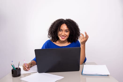 Young business woman working on her laptop and looking at the camera. financial manager